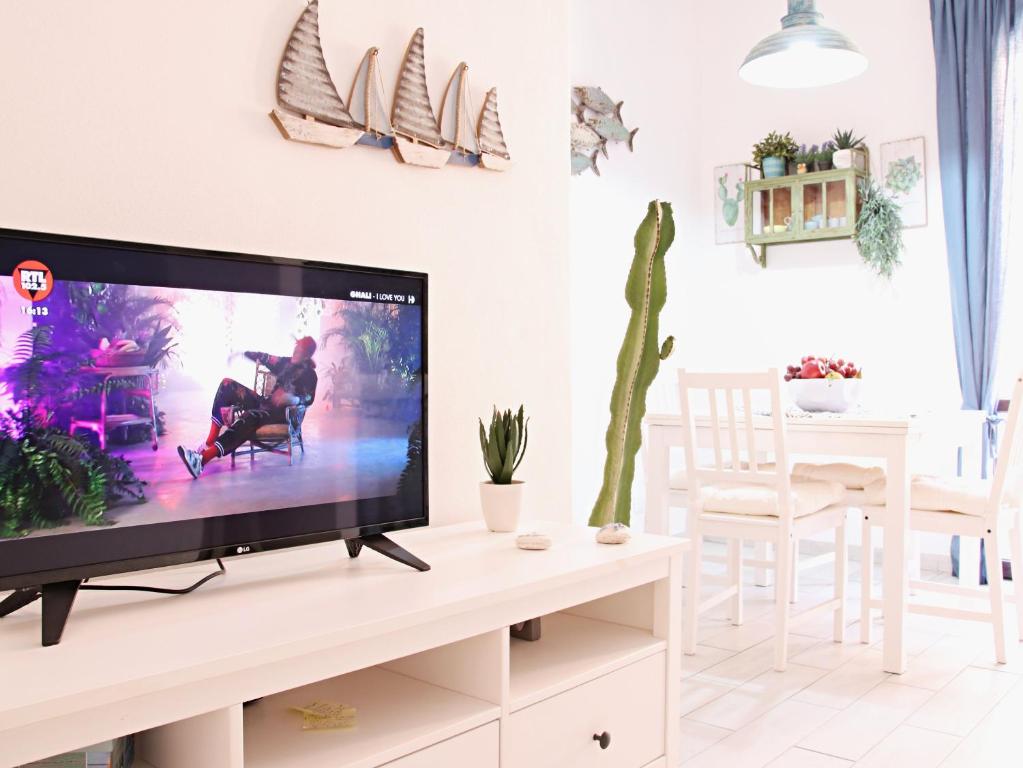 a living room with a flat screen tv on a stand at Blu Home - Bilocale in centro in Lampedusa