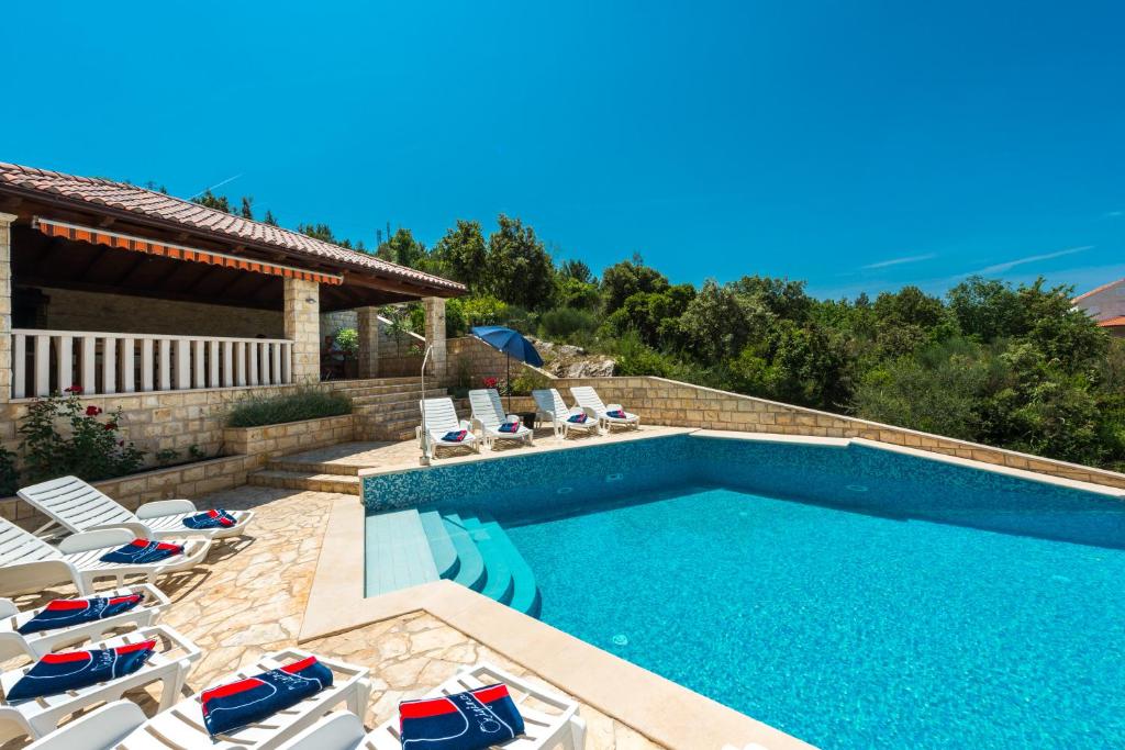 une piscine avec des chaises longues et une piscine dans l'établissement Apartments Villa Elena 3, à Cavtat