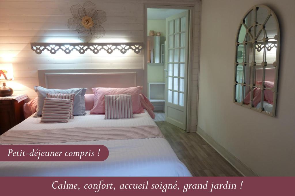 sypialnia z dużym łóżkiem z różowymi i niebieskimi poduszkami w obiekcie Les Bruyères du Mont w mieście Céaux