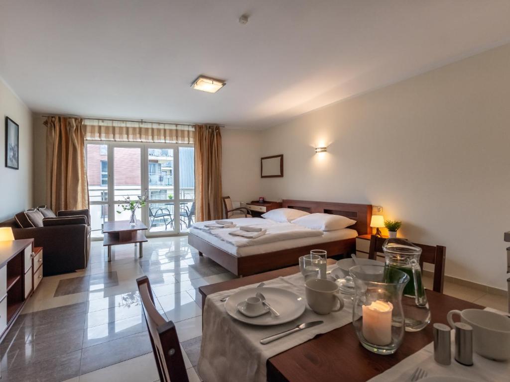 Habitación de hotel con cama y mesa de comedor en VacationClub – Avangard Resort Apartament 23 en Świnoujście