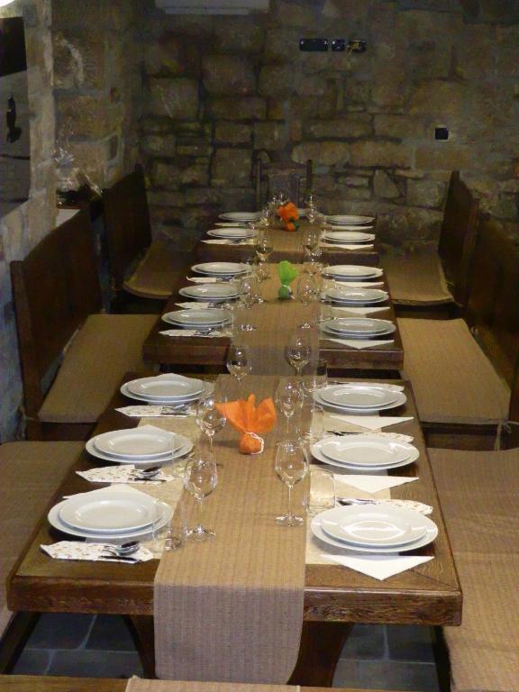 a long table with plates and wine glasses on it at Agroturism Stara Štala in Borut