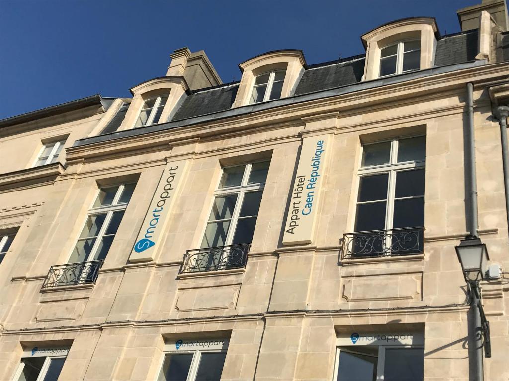 a white building with windows on the side of it at Smart Appart Caen République in Caen