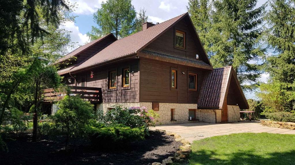 a house with a gambrel roof and a yard at OSTOJA BONDYRZ in AdamÃ³w