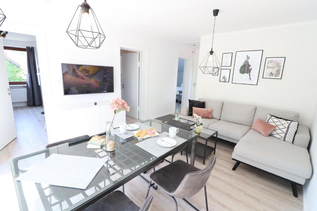 a living room with a glass table and chairs at Meerhaus in Cuxhaven