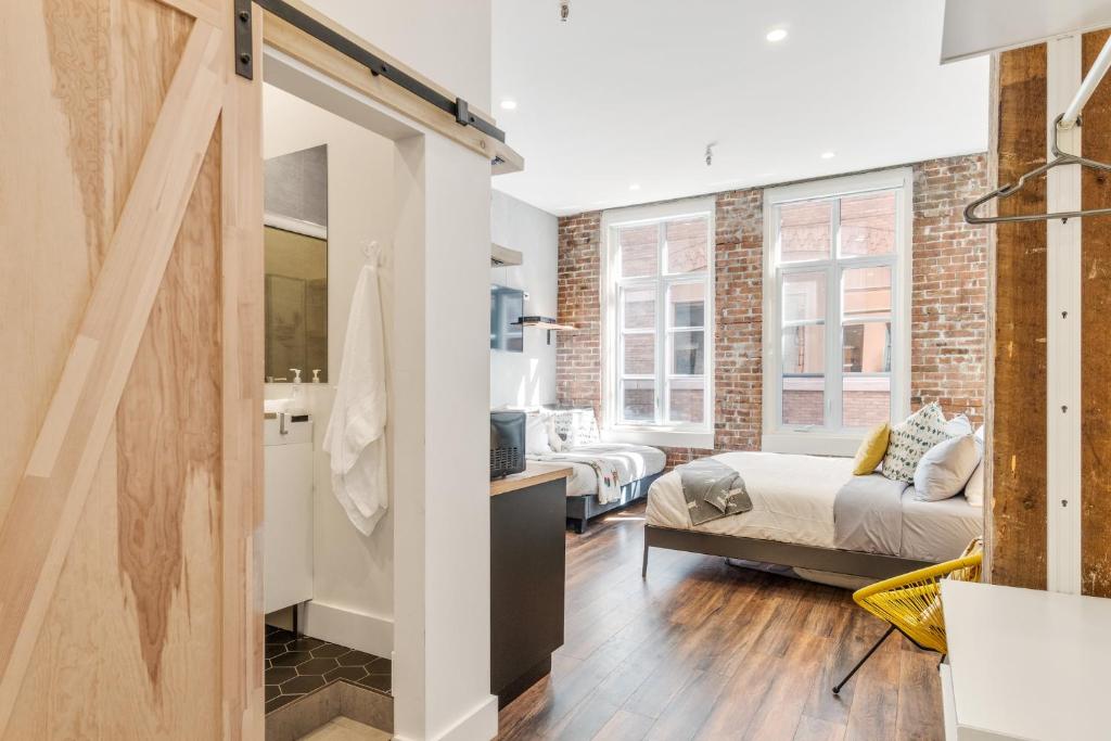 a living room with a bed and a room with a window at INITIAL - LOFT LAMA - Centre-Ville de Québec in Quebec City