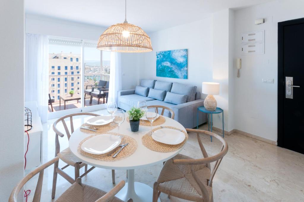 uma sala de estar com uma mesa e cadeiras e um sofá em Calmo Singular Apartments em Gandia