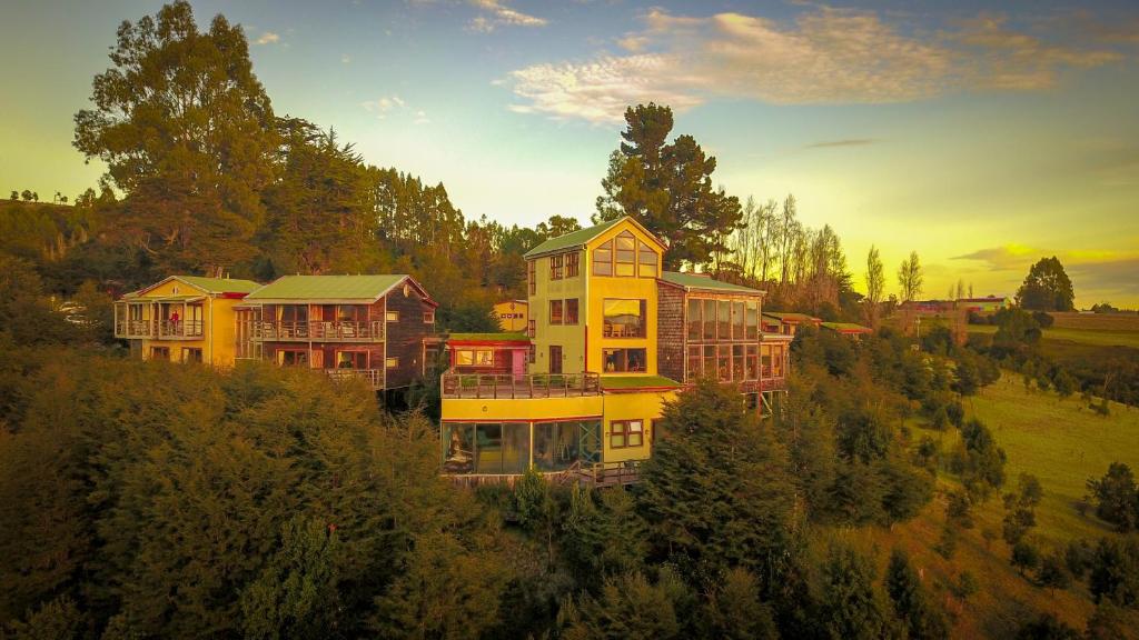 uma casa grande no topo de uma colina com árvores em Hotel Parque Quilquico em Quilquico