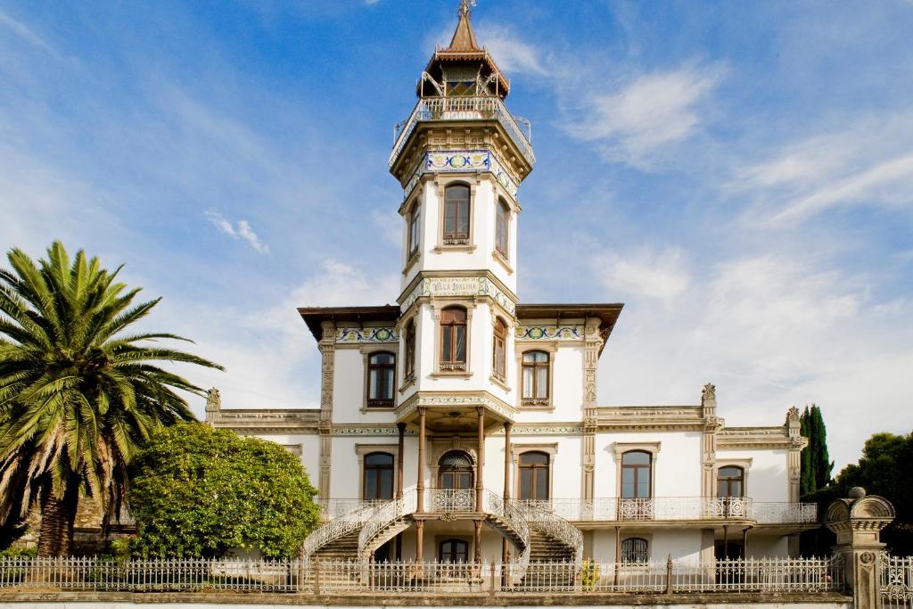 duży biały budynek z wieżą zegarową w obiekcie Palacete Villa Idalina w mieście Caminha