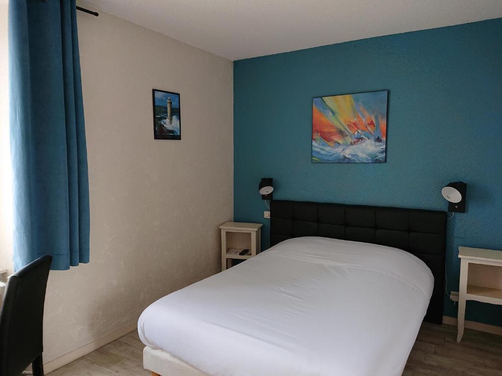 - une chambre avec un lit blanc et un mur bleu dans l'établissement Auberge l'Air de Vent, à Fréhel
