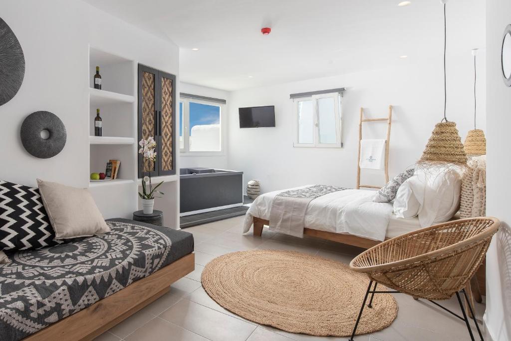 1 dormitorio con 2 camas, silla y sofá en Little Venice Villas en Mykonos ciudad