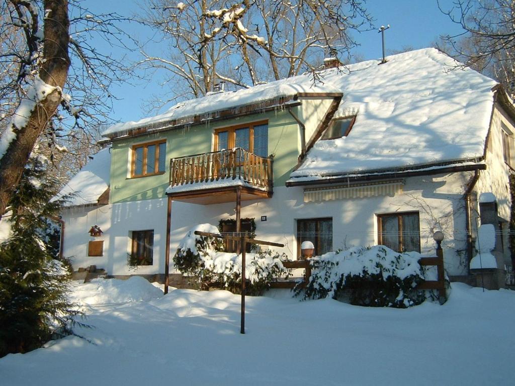 Dolni DvurにあるChalupa Horní Lánovの雪の中のバルコニー付きの家