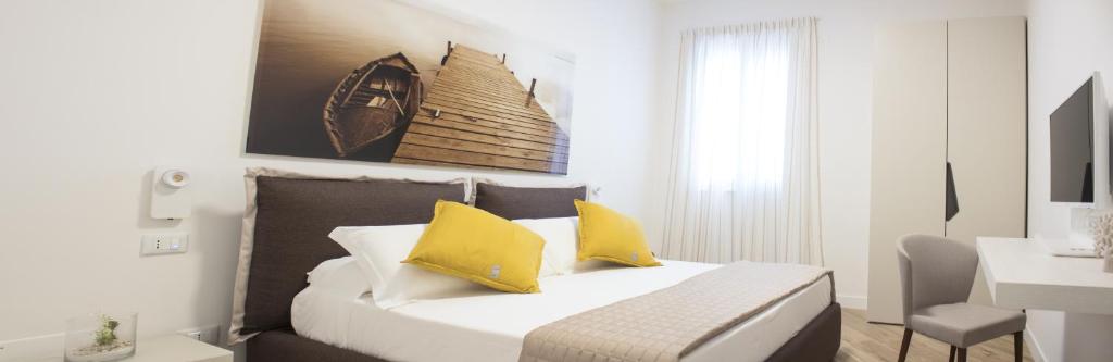 a bedroom with a bed with two yellow pillows at Casa Felice in Savelletri di Fasano