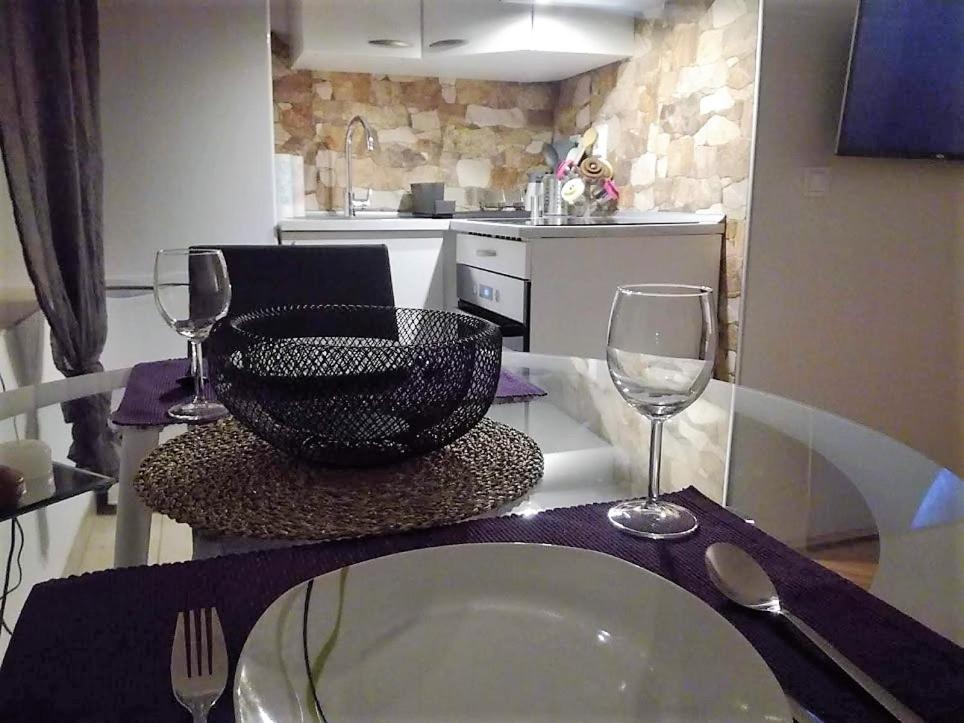 a table with a bowl and two wine glasses on it at Inspired by A.C. in Šibenik
