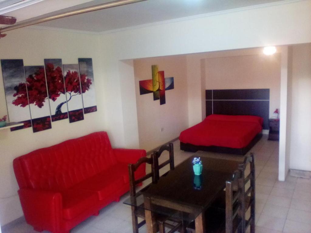 un soggiorno con divano rosso e tavolo di Alto Godoy Apart a Mendoza