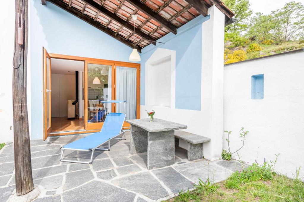 a patio with a table and a blue chair at I Grappoli in Sessa