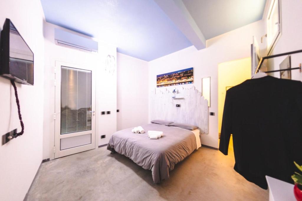 Schlafzimmer mit einem Bett, einem TV und einem Fenster in der Unterkunft A CASA DI MARIANNA in Ravenna