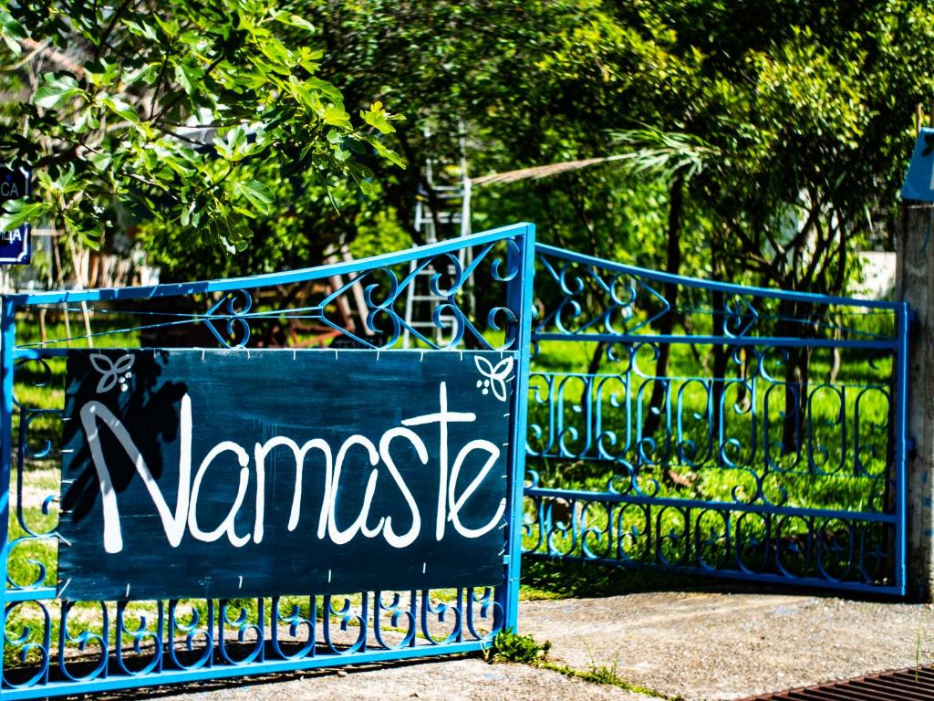 a blue gate with a sign that reads namaste at Namaste Hostel & Camping in Bar