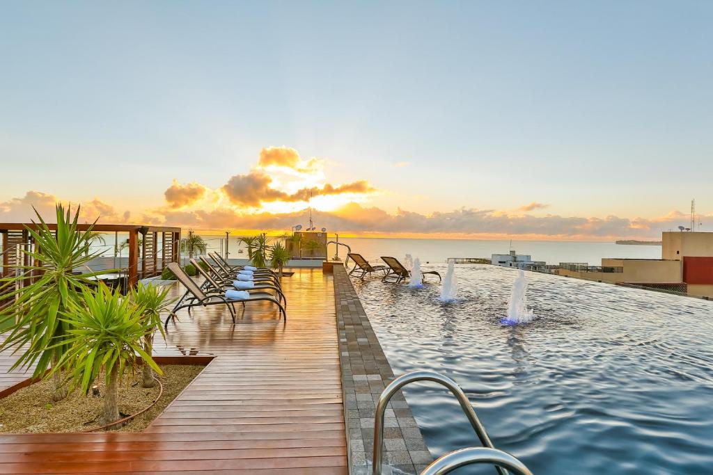 una piscina en un edificio con vistas al océano en Quality Suítes João Pessoa, en João Pessoa