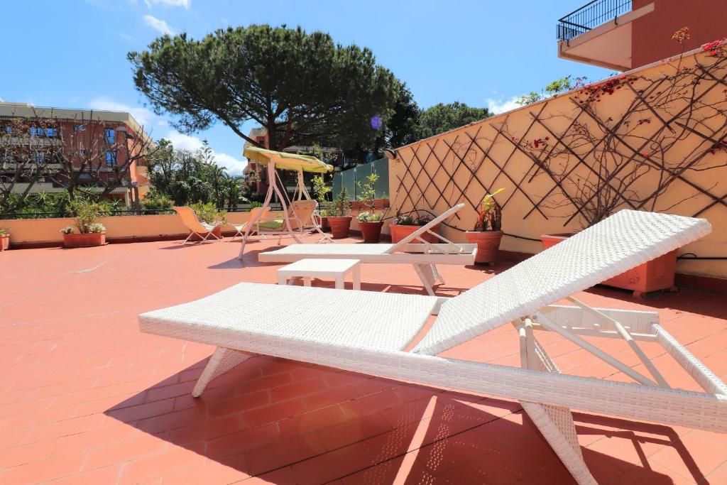 una panchina bianca seduta su un patio in mattoni di La Terrazza Parco Lauro Apartment a Sorrento