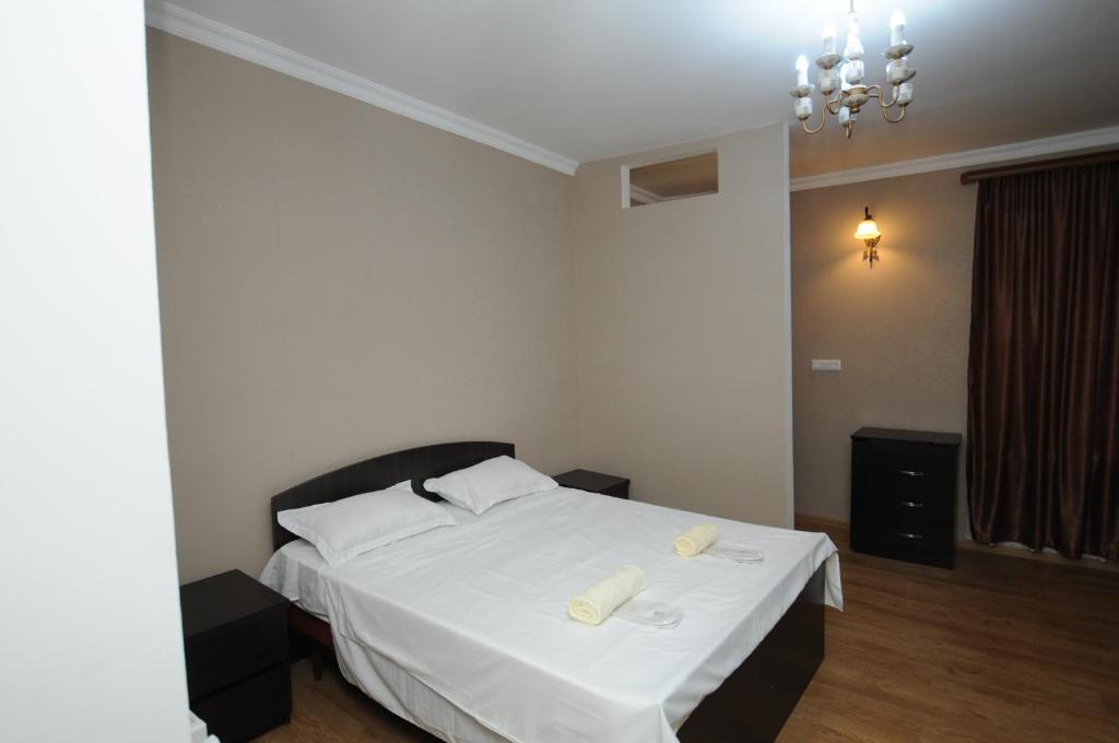 a bedroom with a white bed with two towels on it at SHAKO's Apartments in Tbilisi City