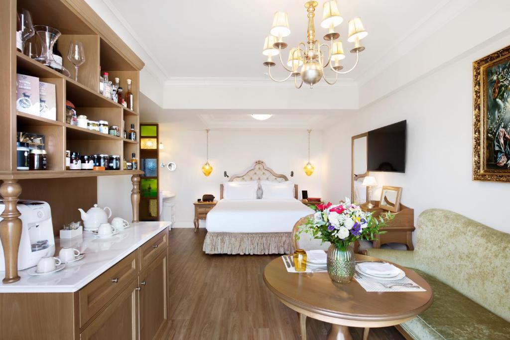 Legacy Gastro Suites في مدينة هيراكيلون: غرفة نوم بسرير وطاولة مع ورد