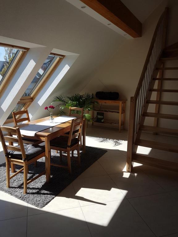 ein Esszimmer mit einem Tisch, Stühlen und einer Treppe in der Unterkunft Ferienwohnung Reblaus in Rüdesheim am Rhein