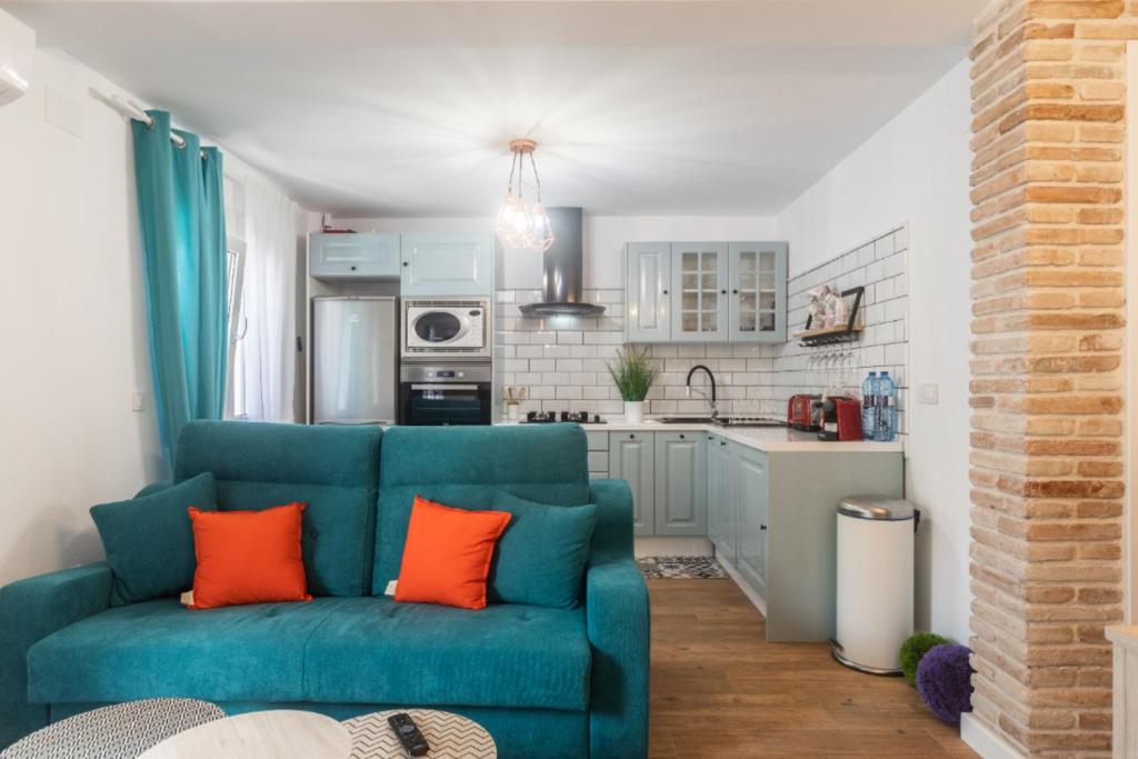 sala de estar con sofá azul y cocina en Exclusive Beach Apartment, en Valencia