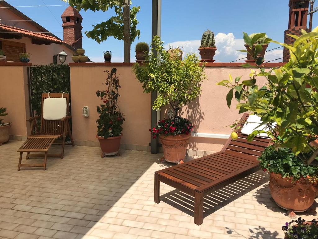een patio met een houten bank en potplanten bij Stella maris holiday house in Sorrento