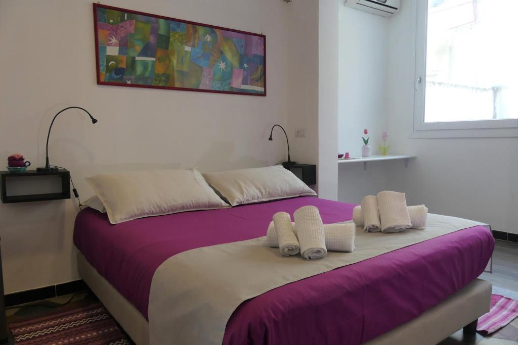 a bedroom with a large bed with purple sheets at Casa Diaz in Cagliari