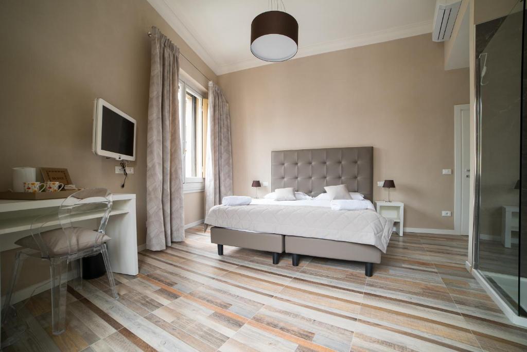 a bedroom with a bed and a desk and a television at D'HOME FLORENCE in Florence