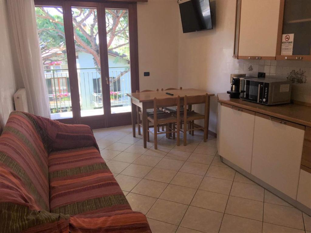 a kitchen and living room with a couch and a table at APPARTAMENTO DALMAZIA 10 in Lido di Jesolo