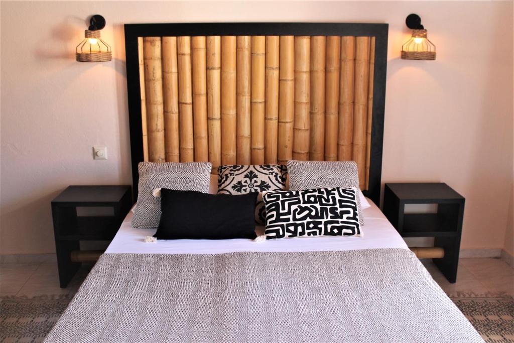 un letto con cuscini sopra di Dali Rooms a Chania