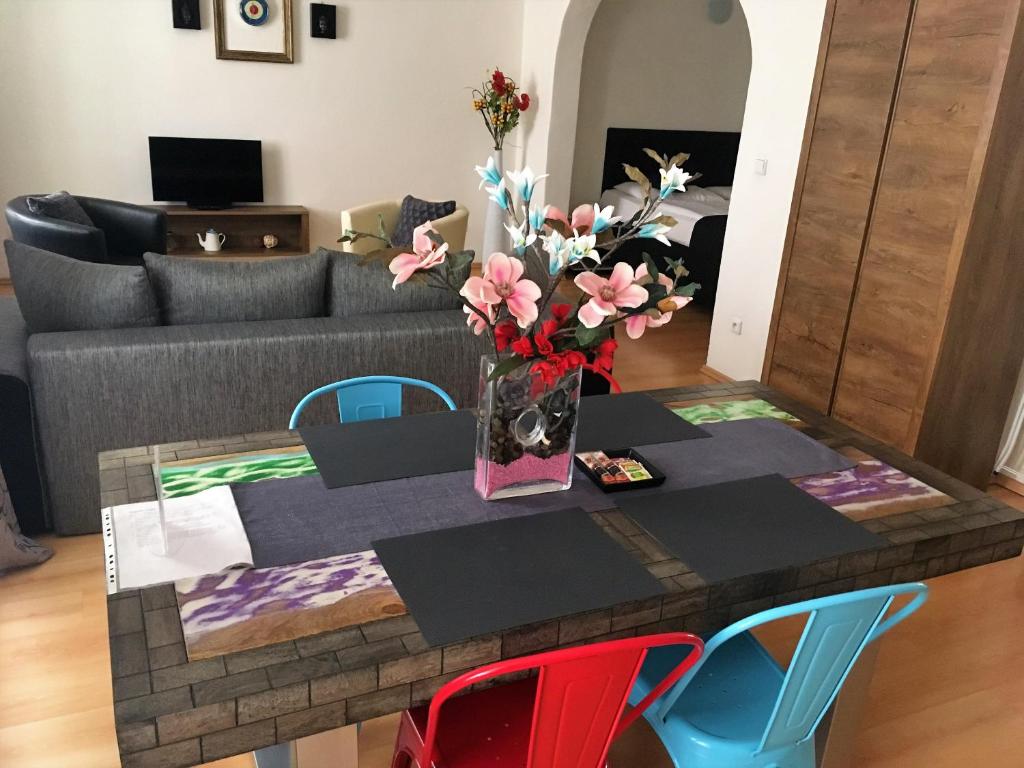 una mesa de comedor con un jarrón de flores. en U Zeleného jalovce en Praga