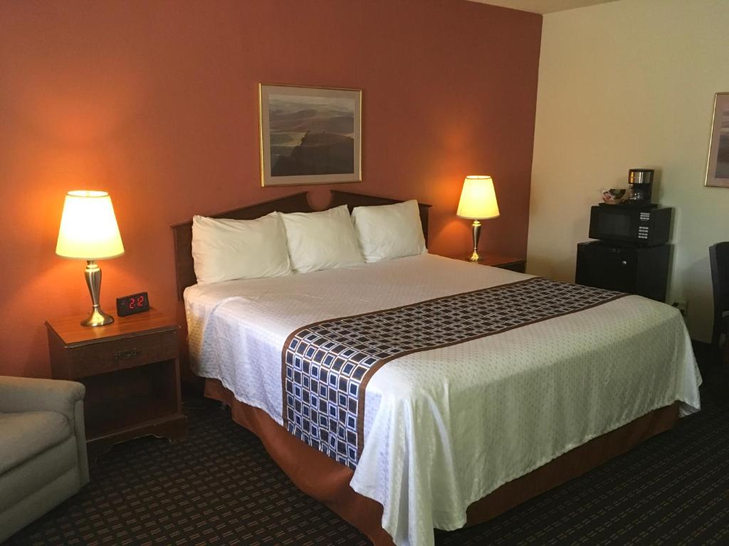 a hotel room with a large bed with two lamps at Budget Inn Lafonda Motel in Liberal