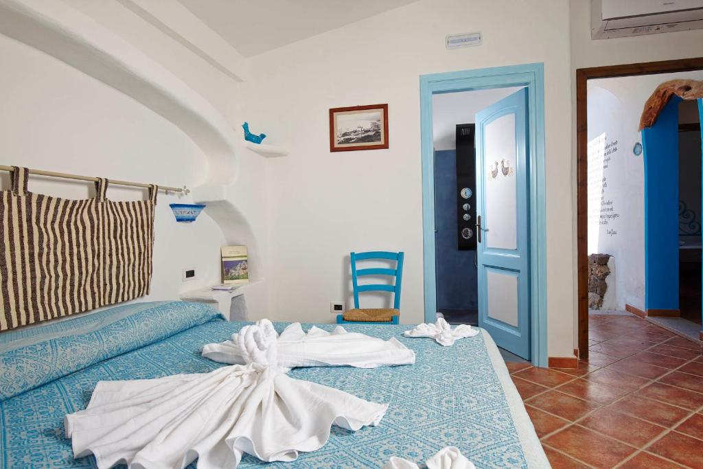 a bedroom with a bed with a dress on it at Agriturismo Codula Fuili in Cala Gonone