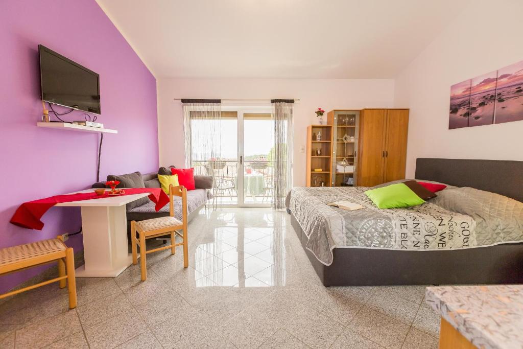 sypialnia z łóżkiem, telewizorem i kanapą w obiekcie Apartment Mery w Puli