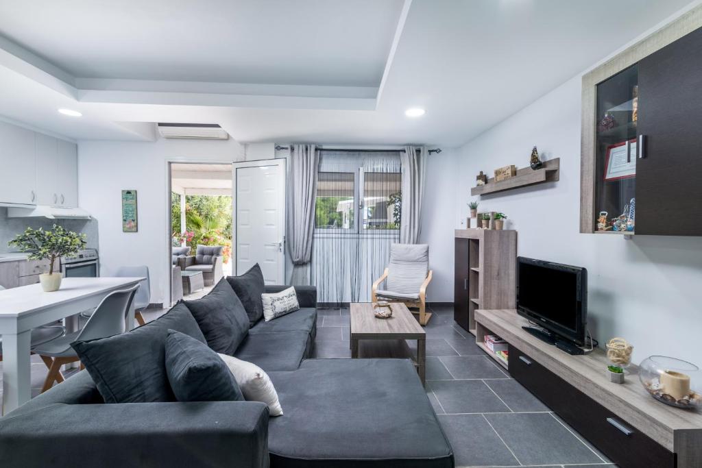 a living room with a blue couch and a tv at Villa Iceberg Mini in Kalamaki Heraklion