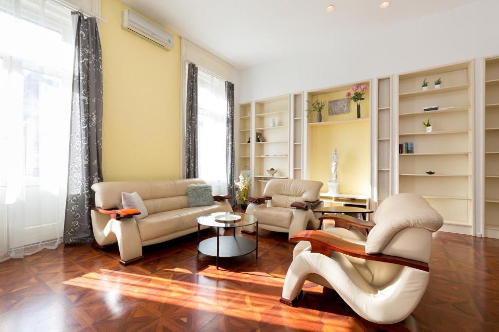 ein Wohnzimmer mit Sofas, Stühlen und einem Tisch in der Unterkunft Luxury central Apartment in Budapest