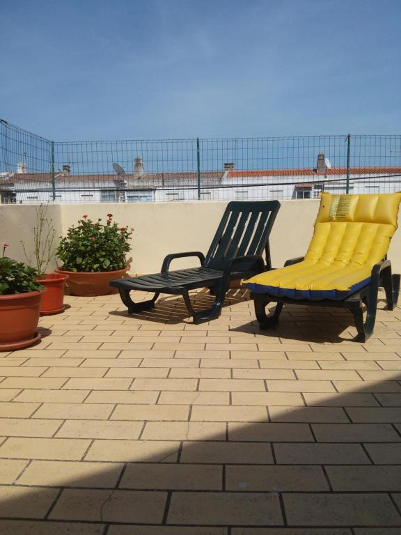 dwa krzesła z żółtymi poduszkami na patio w obiekcie White Sun Hostel w Lagosie