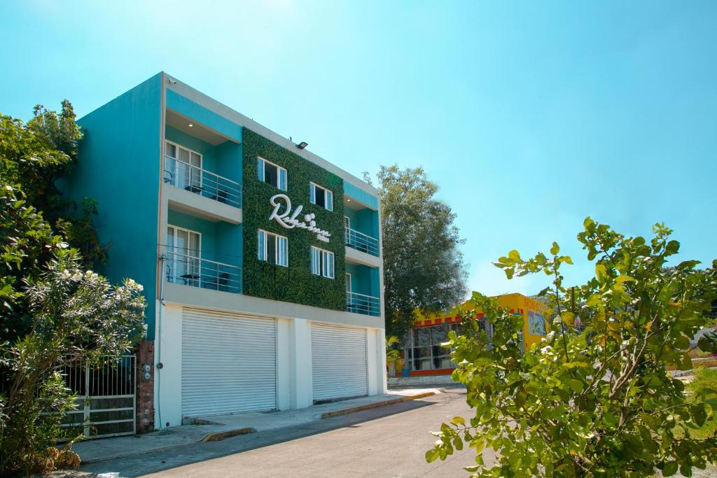 un edificio azul y blanco con garaje en Relax Inn Suites en San Andrés Tuxtla