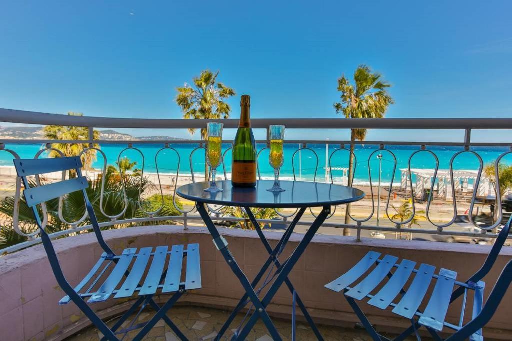 a table with a bottle of wine and two chairs at SEA FRONT SUITE - Panoramic View with Terrace - 85 m in Nice