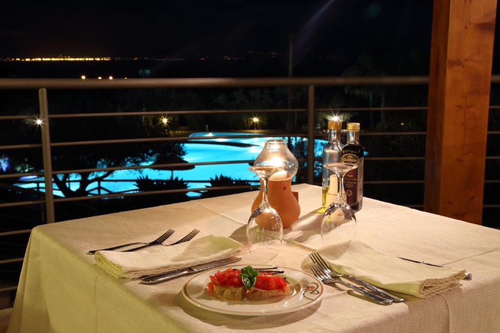 a table with a plate of food on a table with a view at Hotel Santa Chiara in Capo Vaticano