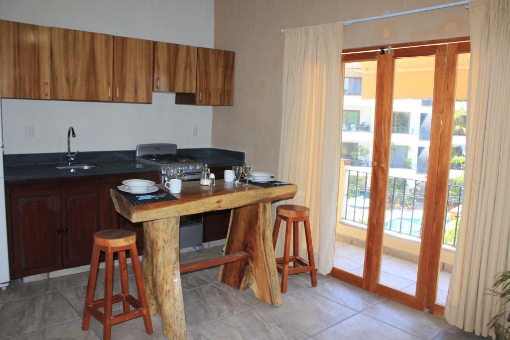 a kitchen with a table and stools in a room at Zona Romántica Casa Las Magnolias in Puerto Vallarta