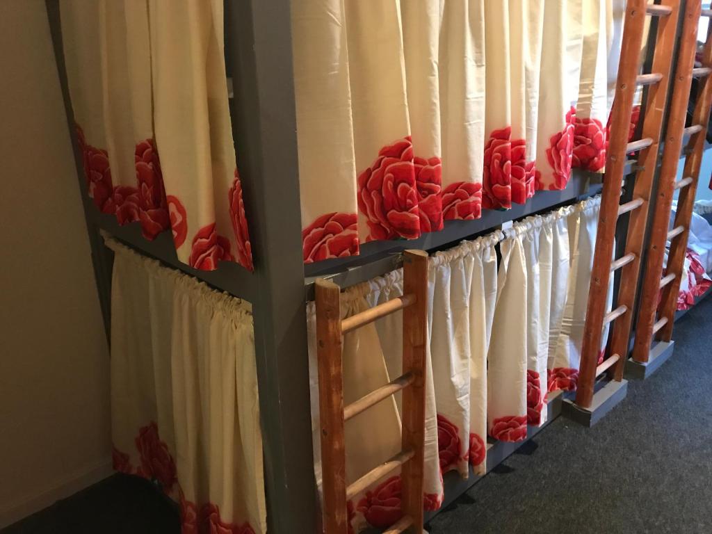 una fila de cortinas en una habitación con rosas rojas en The Birds Nest Hostel en Londres