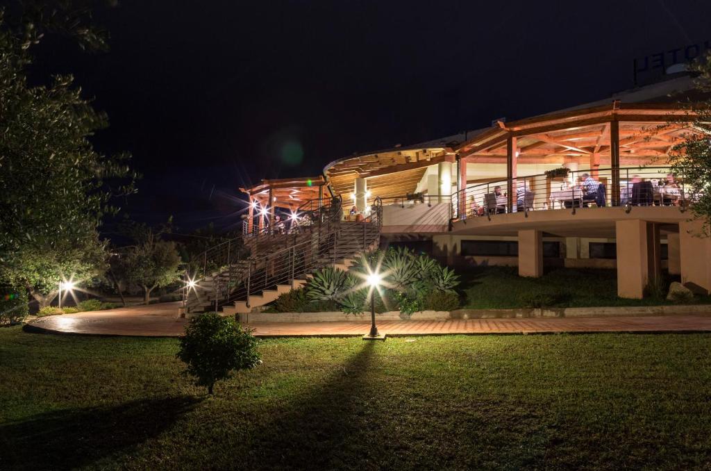 a building with people on the balcony at night at Hotel Santa Chiara in Capo Vaticano