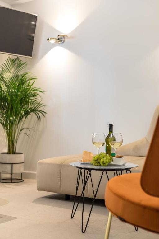 a living room with a couch and a table with wine glasses at Park Residence in Split