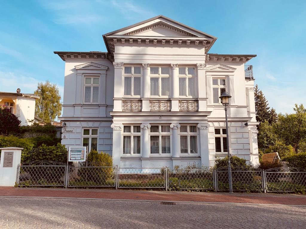 una casa blanca con una valla delante en Villa Franz, en Heringsdorf