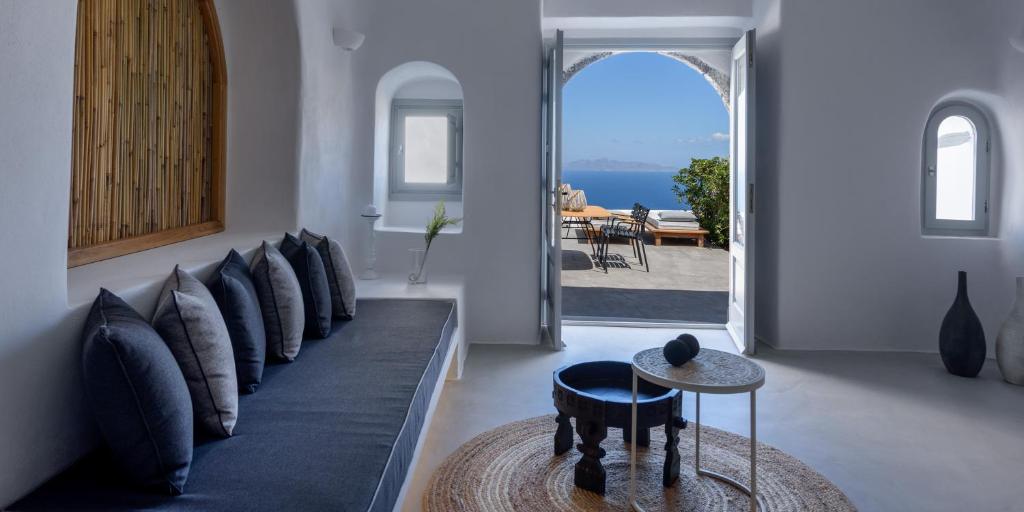 a living room with a couch with pillows and a table at Adele Villa by Senses Collection in Pirgos