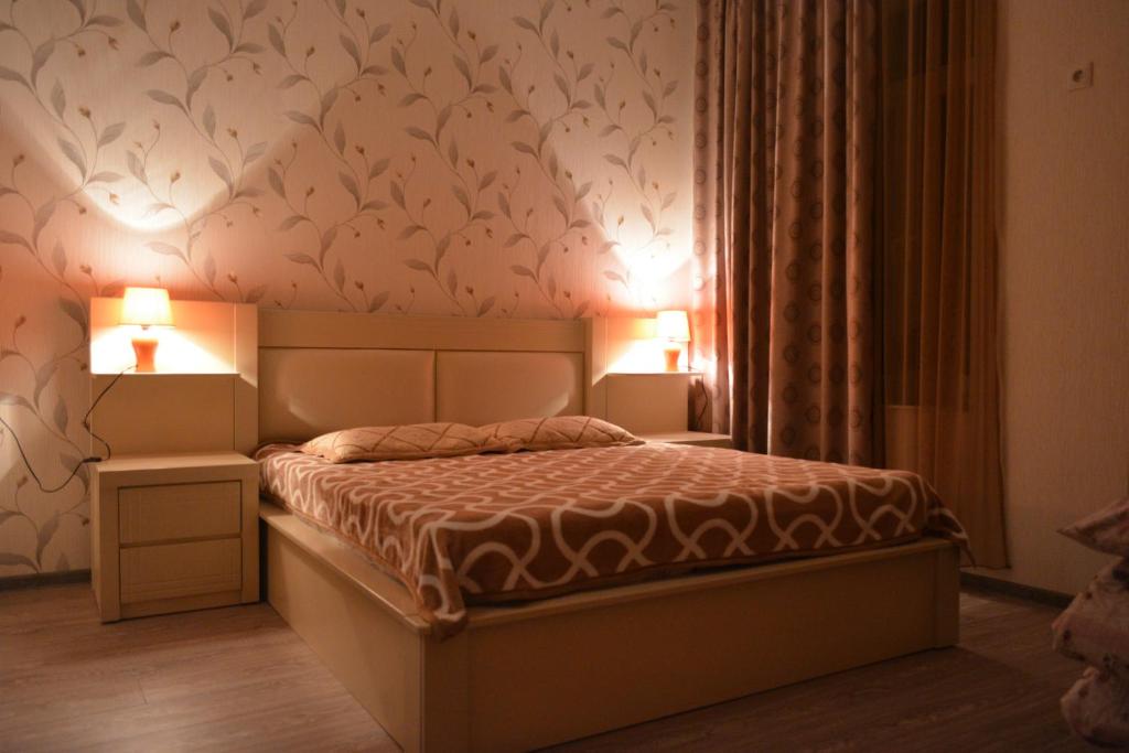 um quarto com uma cama com dois candeeiros em Nana's Apartment em Tbilisi