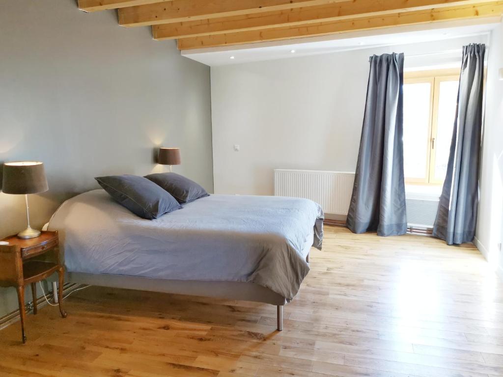 ein Schlafzimmer mit einem Bett mit blauen Kissen darauf in der Unterkunft Maison cosy complètement rénovée in Gertwiller
